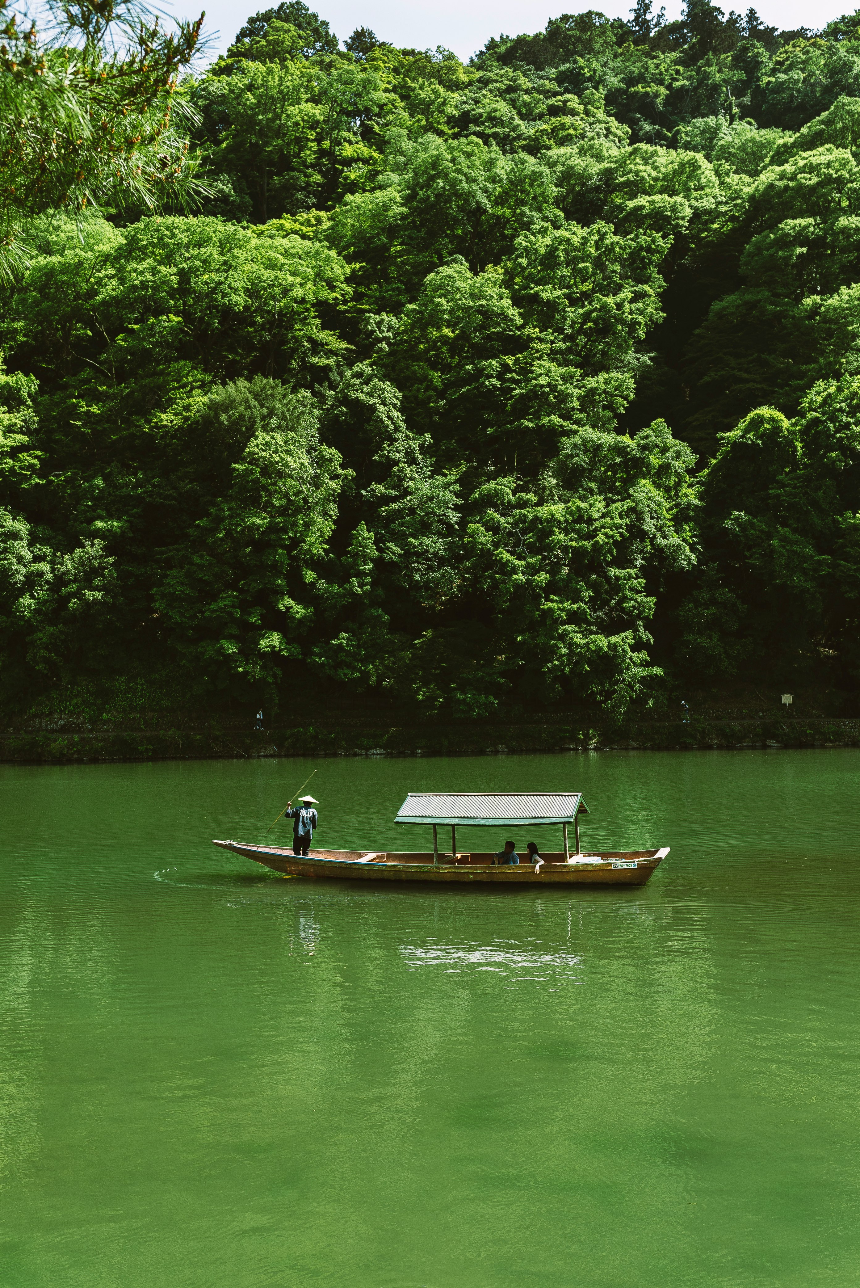 man in brown boat on lake during daytime